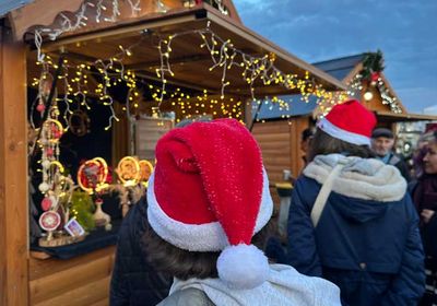 Enfants avec bonnet de Noël devant un chalet