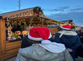 Enfants avec bonnet de Noël devant un chalet